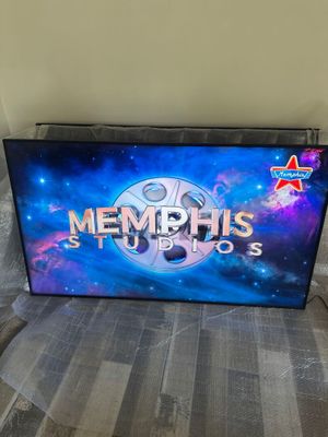 un téléviseur portant l'inscription « Memphis Studios », posé sur un lit