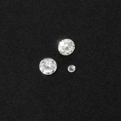 a close up of three diamonds on a black surface