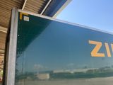 a large green box truck parked in a parking lot