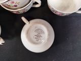 several cups and saucers are lined up on a table