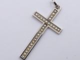 a close up of a cross with pearls on a white surface