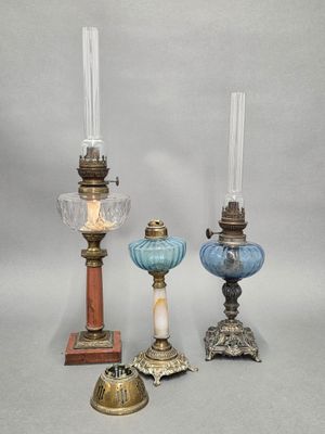three different colored glass candlesticks are sitting on a table