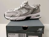 une paire de chaussures New Balance posée sur une boîte
