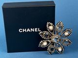 a chanel ring with pearls on it and a black box