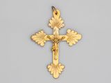 une croix en or sur laquelle figure Jésus, sur fond gris