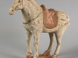 statue d'un cheval avec une selle sur le dos