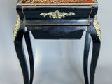 une petite table noire ornée d'un motif doré