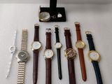 de nombreuses montres et un présentoir à montres posés sur la table
