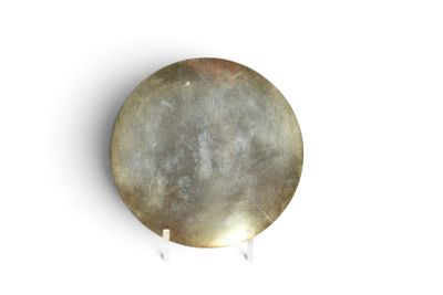 une assiette en argent avec un fond blanc sur une surface blanche