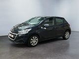 Une voiture noire est garée dans une pièce aux murs blancs.