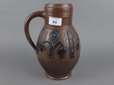 a brown vase with a black design on it