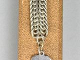 a close up of a metal chain with a dog tag on it