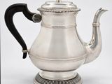 an antique silver teapot with a black handle on a white background