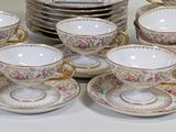 a lot of cups and saucers sitting on a table
