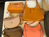 many bags and purses on a table in a store
