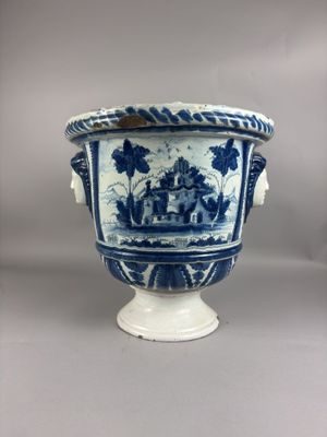 un vase bleu et blanc posé sur un socle blanc