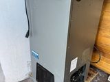 un climatiseur industriel installé dans un garage, contre un mur