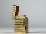 une photo d'un étui à cigarettes en or posé sur une table blanche