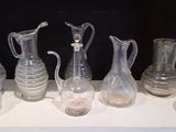 de nombreux vases en verre posés sur une étagère