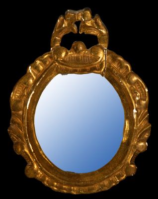 an image of a gold mirror with a bird on it ' s face