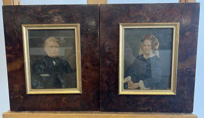 two framed portraits of a woman and a man sitting on a chair