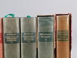 several books are lined up in a row on a table