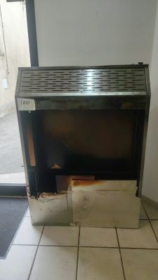 a fire place in the corner of a room with tile flooring