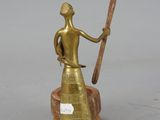 a gold statue of a woman holding a baseball bat