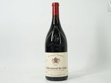 an old bottle of red wine sitting on a white surface