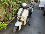 un scooter garé à côté d'un banc