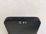 the back of a black iphone with a small battery on it