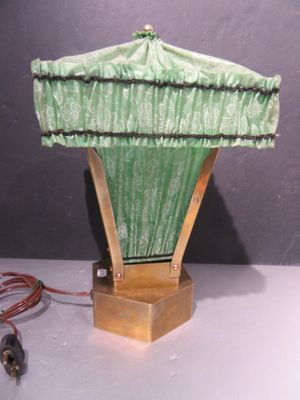une lampe surmontée d'un abat-jour vert