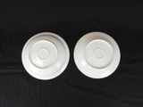 pair of white porcelain saucers on a black table cloth