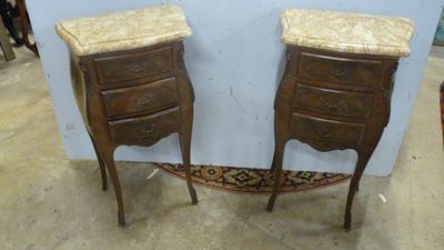 une paire de tables de chevet anciennes avec plateau en marbre, posées sur des pieds, dans une pièce