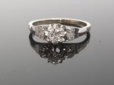 a close up of a diamond ring on a reflective surface