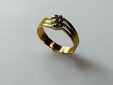 a close up of a gold ring on a white surface