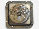a clock that is on the side of a metal plate