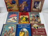 several children ' s books are lined up on a white surface