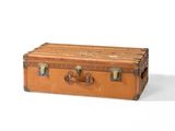 une vieille valise posée sur une surface blanche
