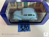 une petite voiture bleue dans une boîte bleue posée sur une table