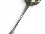 an old spoon with a spoon handle on a white surface
