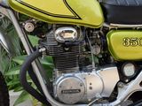 a close up of a yellow motorcycle parked on the side of the road
