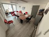 a room with a table, chairs and a refrigerator in it
