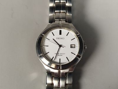gros plan d'une montre sur une surface blanche