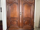 une grande armoire en bois au milieu d'une pièce