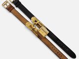 a close up of two belts with gold buckles on a white background