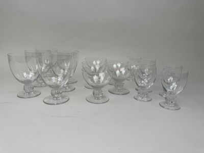 six verres à vin transparents alignés sur une surface blanche