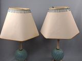 pair of blue and white lamps on a table with a white shade