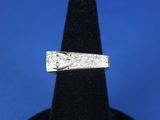 un gros plan d'une bague en diamant posée sur un présentoir noir
