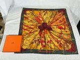 a yellow and red scarf on a bed with an orange book
